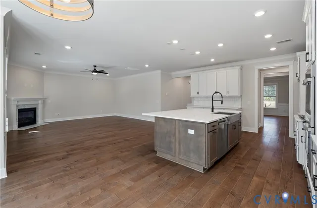 a kitchen with kitchen island granite countertop a sink and a stove top oven