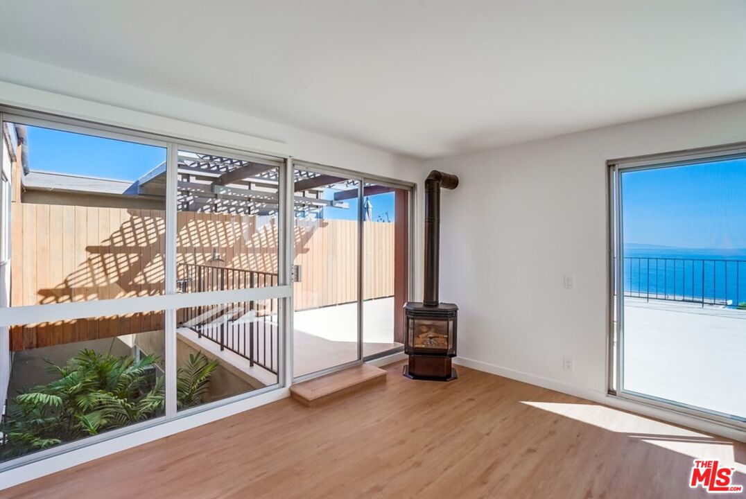 18241 Coastline Drive, Unit 2 Malibu, CA 90265 - Photo 12 of 45 an empty room with wooden floor and windows
