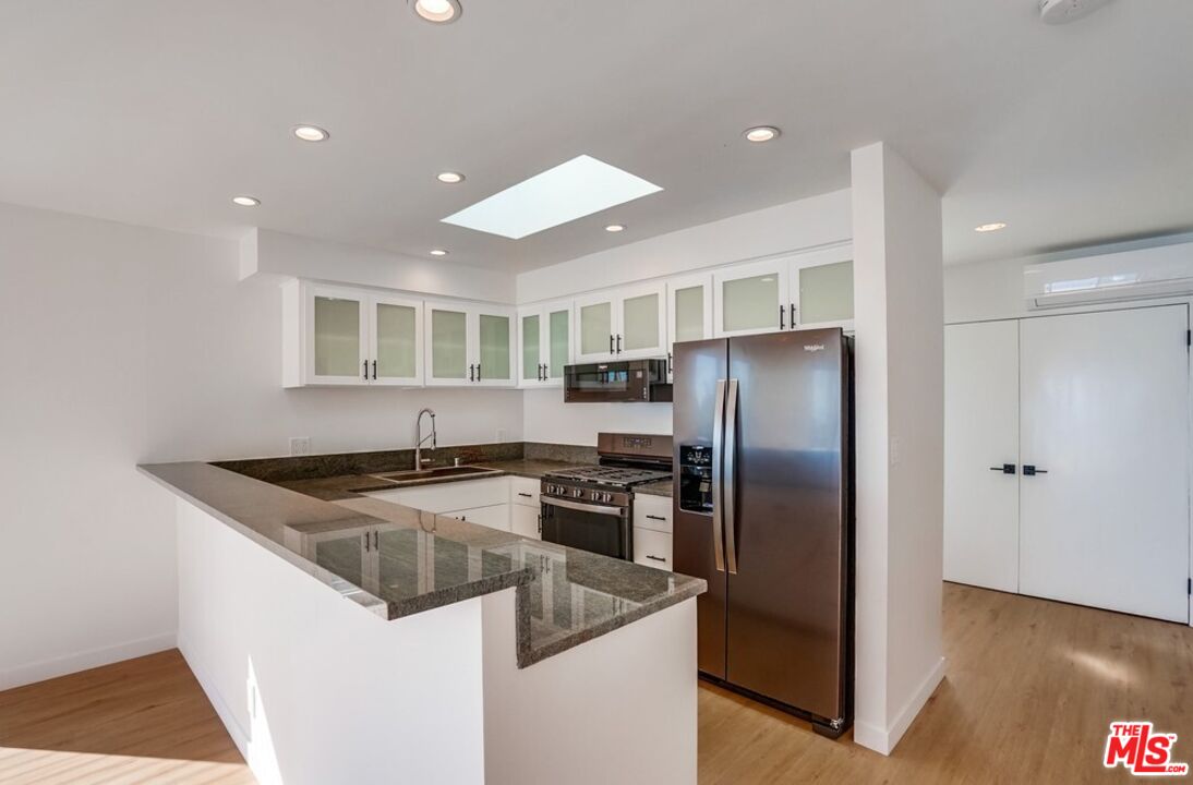18241 Coastline Drive, Unit 2 Malibu, CA 90265 - Photo 14 of 45 a kitchen with stainless steel appliances granite countertop a refrigerator a sink and a stove