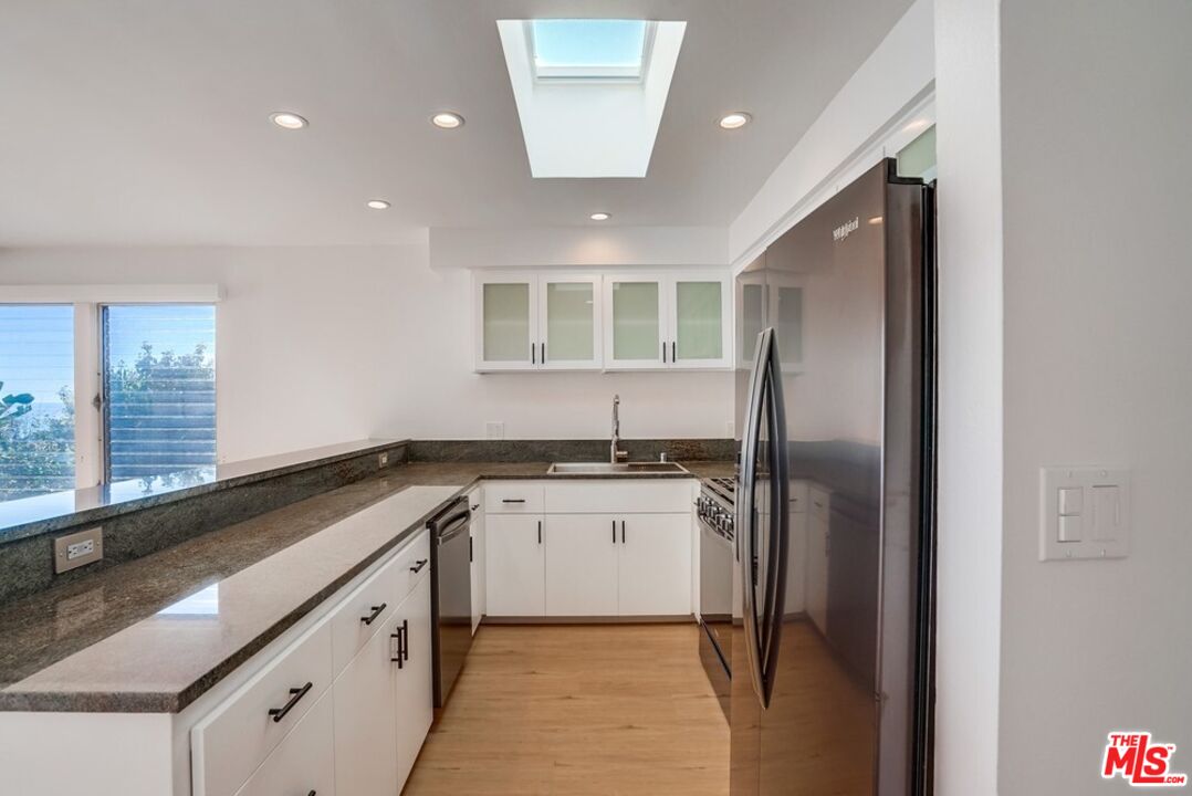 18241 Coastline Drive, Unit 2 Malibu, CA 90265 - Photo 15 of 45 a kitchen with granite countertop stainless steel appliances a sink and a refrigerator