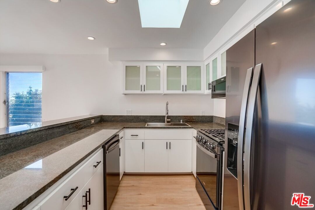 18241 Coastline Drive, Unit 2 Malibu, CA 90265 - Photo 16 of 45 a kitchen with stainless steel appliances granite countertop a sink stove and refrigerator