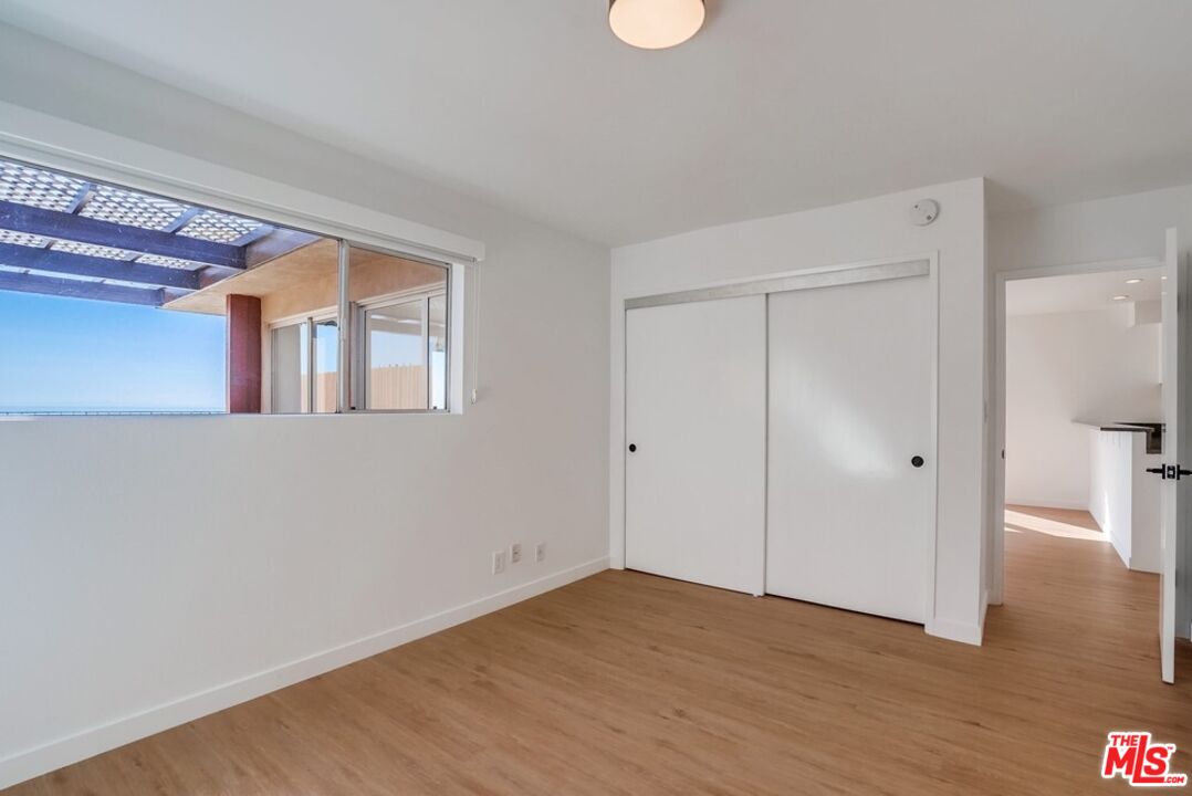 18241 Coastline Drive, Unit 2 Malibu, CA 90265 - Photo 26 of 45 a view of an empty room with wooden floor and a window
