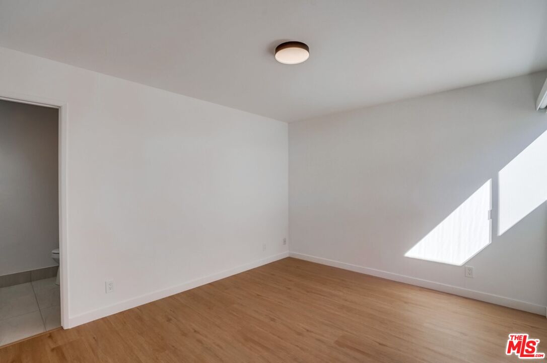 18241 Coastline Drive, Unit 2 Malibu, CA 90265 - Photo 28 of 45 a view of an empty room with wooden floor and a window