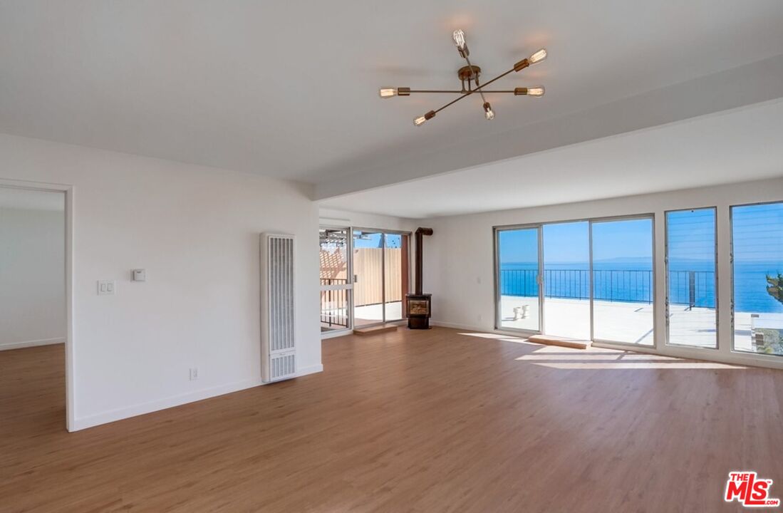 18241 Coastline Drive, Unit 2 Malibu, CA 90265 - Photo 7 of 45 a view of an empty room with a window and wooden floor