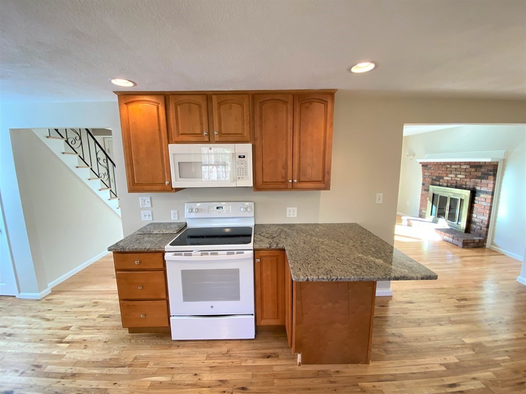 15 Appaloosa Drive, Unit 15 Methuen, MA 01844 - Photo 10 of 23 a kitchen with stainless steel appliances granite countertop a stove a sink and a microwave