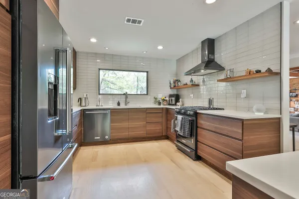 a kitchen with stainless steel appliances kitchen island granite countertop a sink and a stove top oven