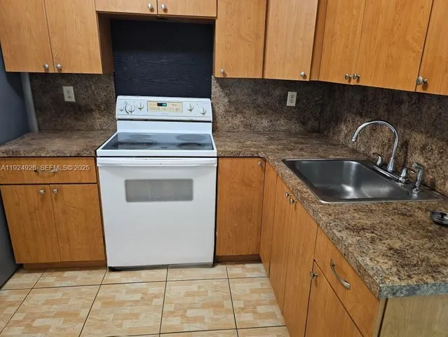 a view of a kitchen with a sink a washer and dryer