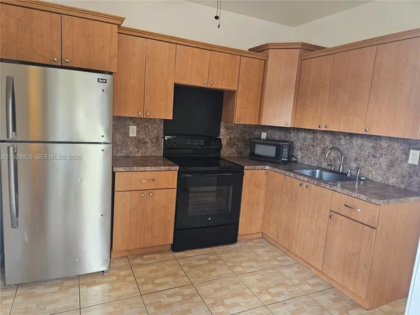 a kitchen with a refrigerator sink and cabinets