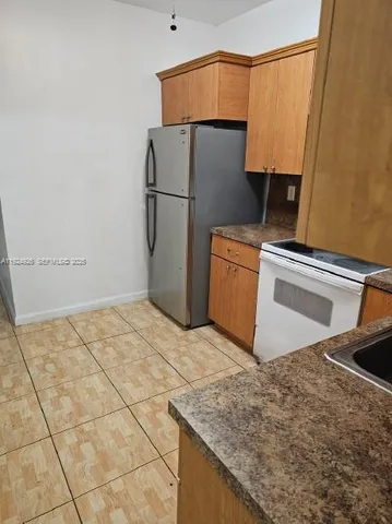 a kitchen with a refrigerator and a sink