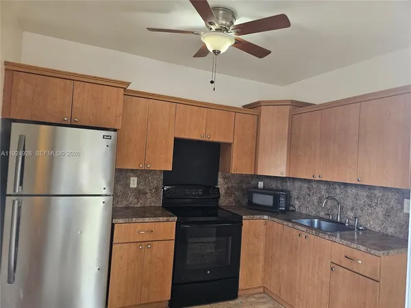 a kitchen with stainless steel appliances granite countertop a refrigerator a stove top oven a sink and dishwasher