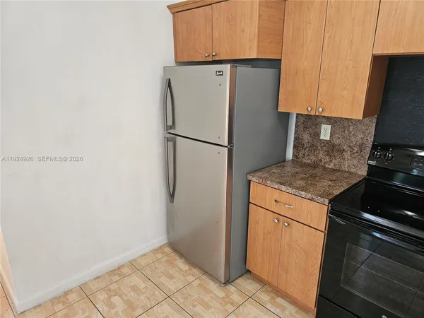 a white refrigerator freezer and a stove sitting inside of a kitchen