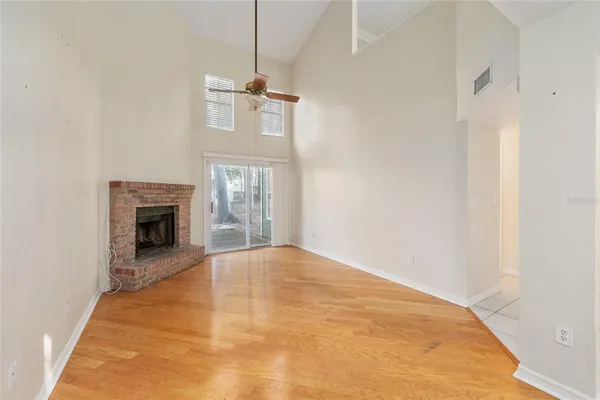 a view of empty room with wooden floor and fireplace