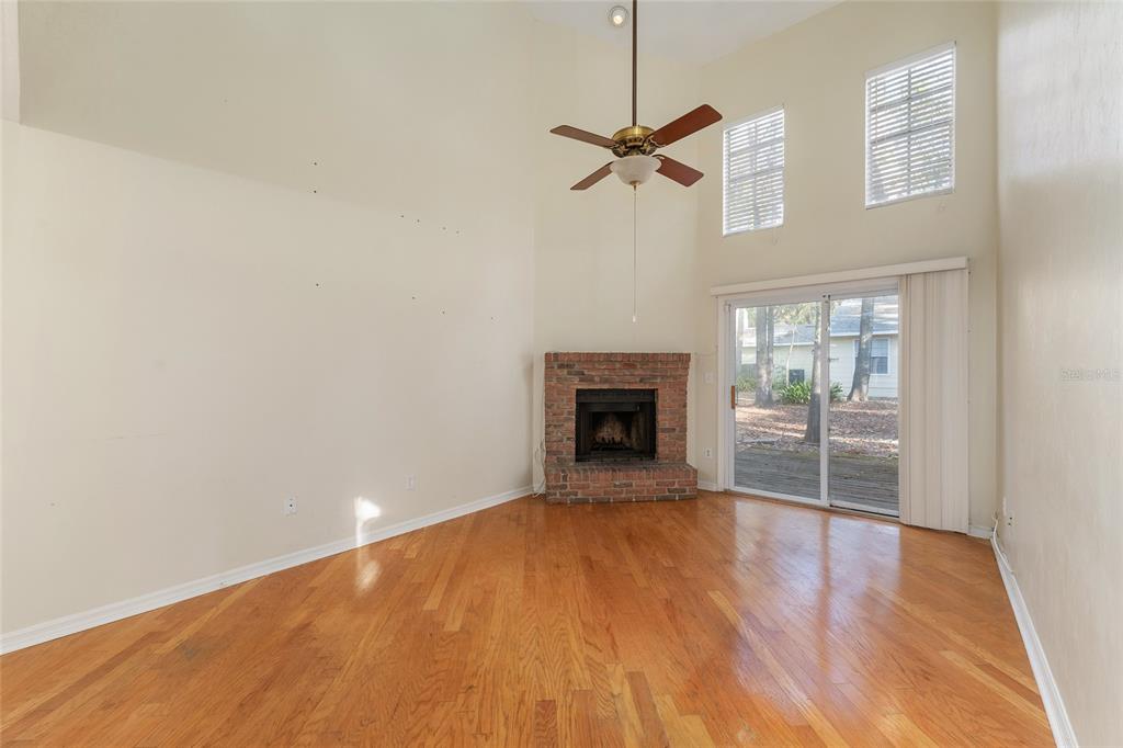 345 Northwest 48th Boulevard, Unit K Gainesville, FL 32607 - Photo 13 of 50 a view of empty room with wooden floor and fireplace