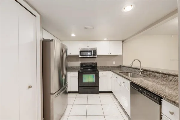 a kitchen with stainless steel appliances granite countertop a sink stove and microwave