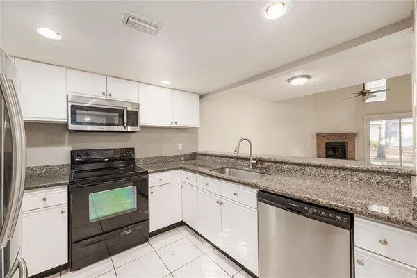 a view of a kitchen with a sink and refrigerator in it