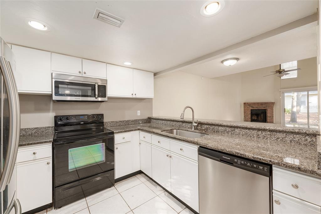 345 Northwest 48th Boulevard, Unit K Gainesville, FL 32607 - Photo 20 of 50 a kitchen with stainless steel appliances granite countertop a sink stove and microwave