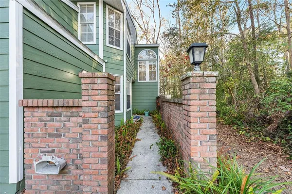 a pathway of a house with a yard and potted plants