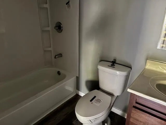 a bathroom with a sink a toilet a mirror and shower