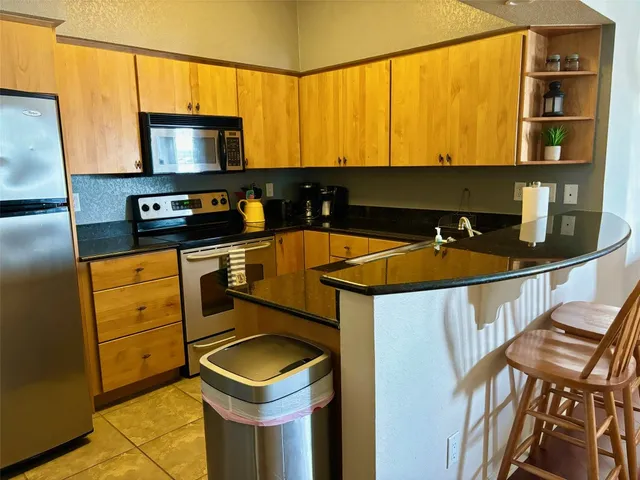 a kitchen with stainless steel appliances a stove a sink and a microwave