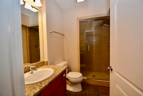 a bathroom with a granite countertop sink toilet and shower