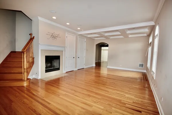 a view of empty room with wooden floor and fireplace
