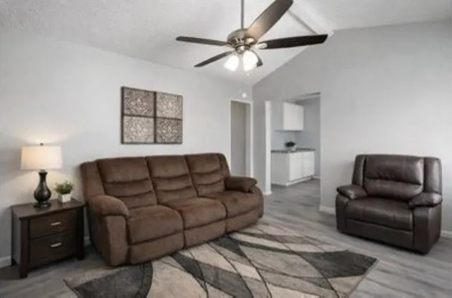a living room with furniture and a ceiling fan