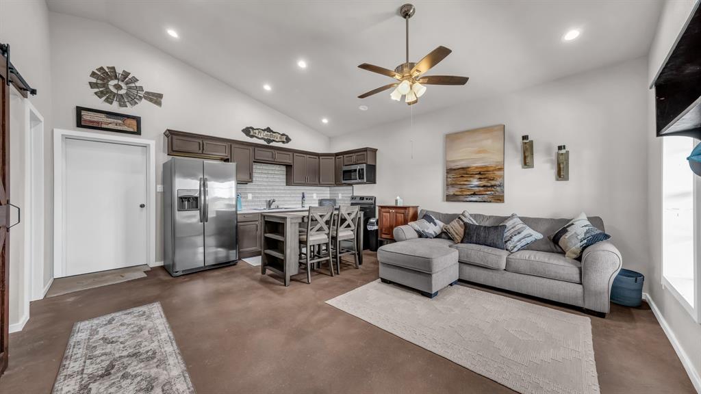 3810 Fairview Road Millsap, TX 76066 - Photo 7 of 25 Living area with a barn door, recessed lighting, ceiling fan, high vaulted ceiling, and concrete floors
