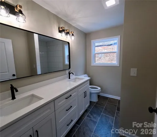 a bathroom with a toilet sink and mirror
