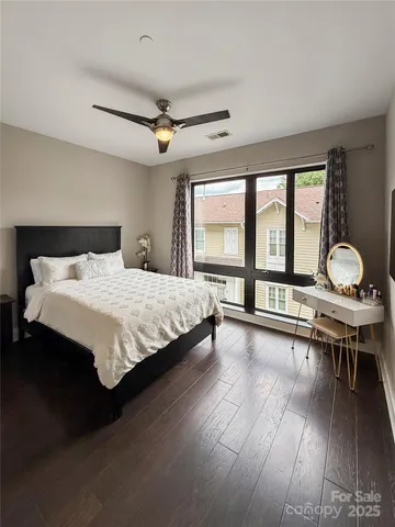 a bedroom with a bed mirror and a large window