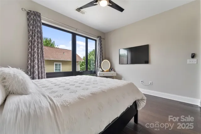 a bedroom with a bed and a flat tv screen on the dresser