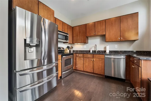 a kitchen with granite countertop stainless steel appliances and wooden cabinets