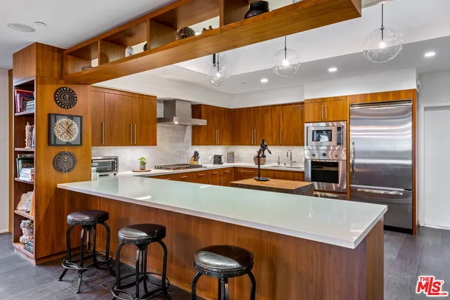 a kitchen with stainless steel appliances granite countertop a sink and a refrigerator