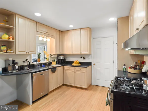 a kitchen with a sink cabinets and wooden floor