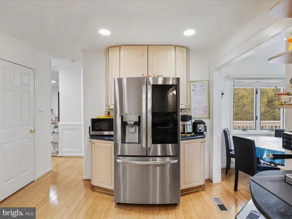 a kitchen with stainless steel appliances wooden floor and refrigerator