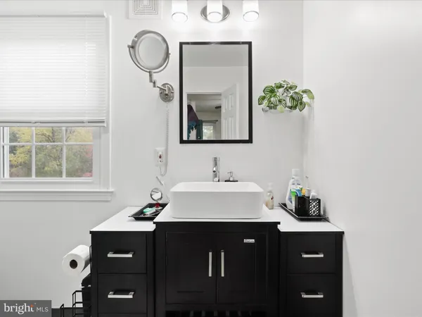 a bathroom with a sink vanity and a mirror