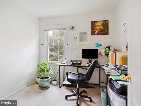 a view of a workspace with furniture and a window