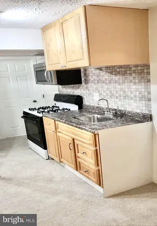 a kitchen with stainless steel appliances granite countertop a sink stove and microwave