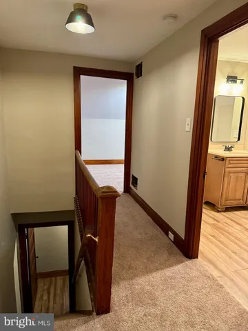 a view of a hallway with wooden floor and chair