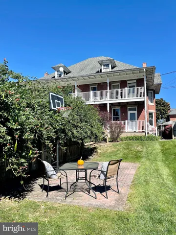 a view of a patio with table and chairs with plants and wooden fence