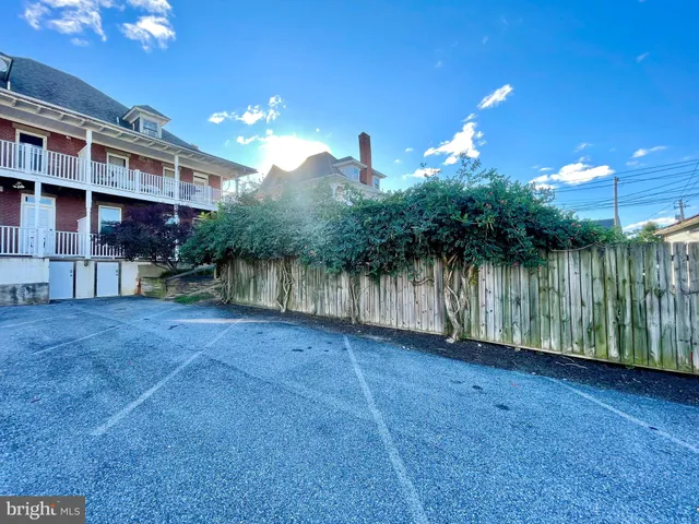 a view of a house with a yard and a wooden fence