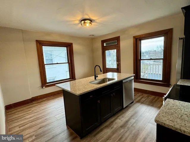 a kitchen with sink cabinets and wooden floor