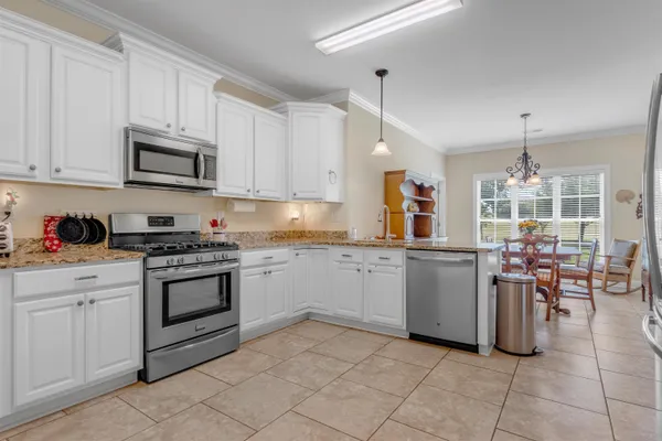 a kitchen with granite countertop cabinets stainless steel appliances and a sink