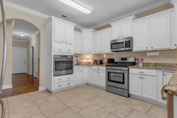 a kitchen with granite countertop white cabinets and appliances