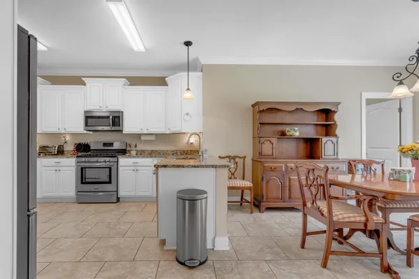 a kitchen with a stove cabinets and chairs