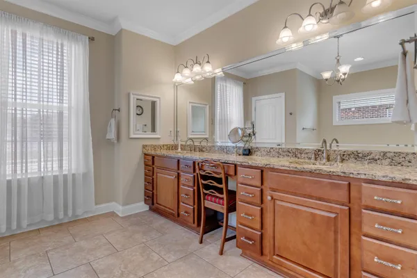 a bathroom with a granite countertop double vanity sink and a mirror