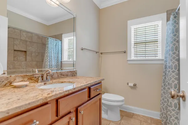 a bathroom with a granite countertop sink toilet a large mirror and shower