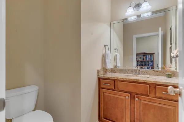 a bathroom with a granite countertop toilet sink and mirror