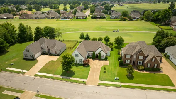 an aerial view of a house with a garden and lake view