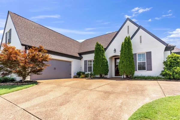 a front view of house with yard and trees around