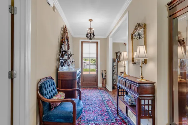 a living room with furniture a piano and a chandelier
